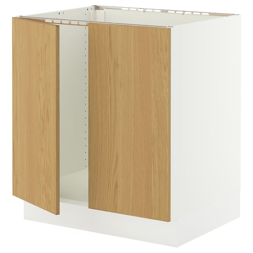 A white SEKTION kitchen cabinet with light oak doors and integrated hinges, designed for easy assembly and strong durability.