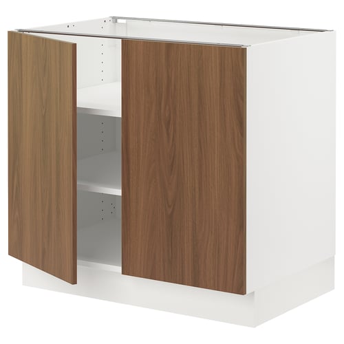 A modern SEKTION kitchen cabinet with white frames and wooden-brown doors. It has adjustable shelves and snap-on hinges.