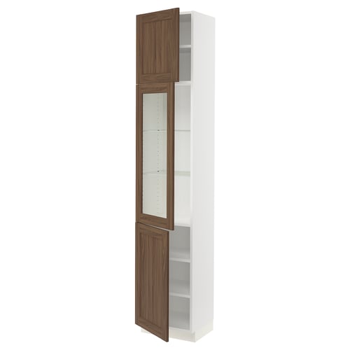 A SEKTION kitchen cabinet with white and walnut-colored doors, featuring glass panels and adjustable shelves.