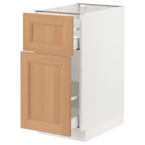 An ikea SEKTION kitchen cabinet with light oak doors open, revealing white inner shelves.