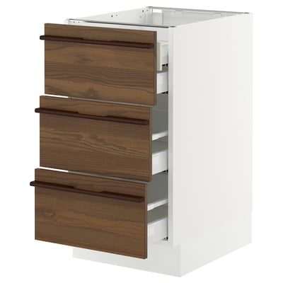 A SEKTION kitchen cabinet with dark brown stained ash veneer drawers and white base.