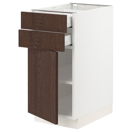 A modern kitchen cabinet with dark brown wooden drawers and a white base. It has an open drawer and door, revealing adjustable shelves inside.