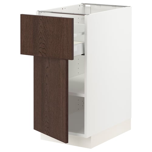 White kitchen cabinet with dark brown wooden door, partially open, showing shelves inside.