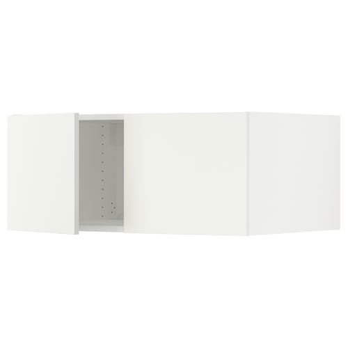 A white SEKTION kitchen cabinet with an open door, exposing adjustable shelves inside.