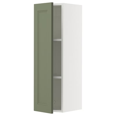 Depicts a tall, narrow white wall cabinet with a singular grey-green door partially open, revealing adjustable shelves inside.