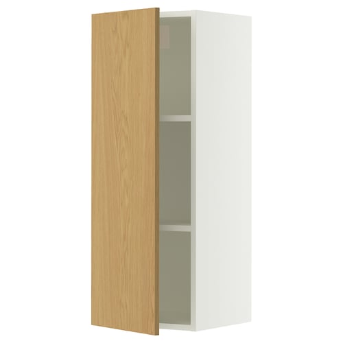 A white SEKTION wall cabinet with a light oak veneer door open, revealing an adjustable shelf inside.