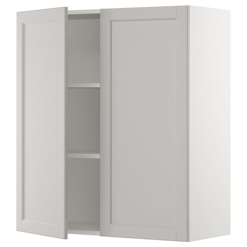 A white SEKTION kitchen cabinet with two open doors revealing an empty shelf.