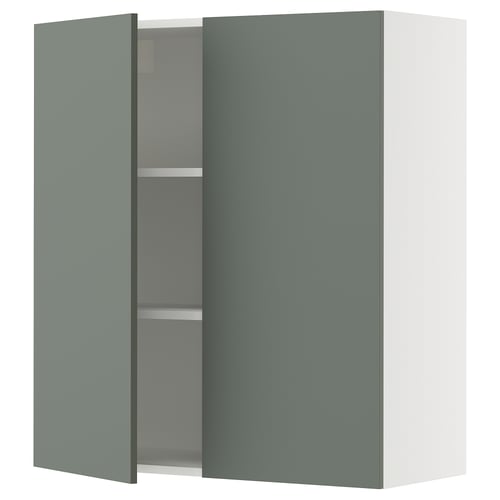 A teal SEKTION wall cabinet with a white frame, two doors, and adjustable shelves. It has a modern design with soft-closing hinges.