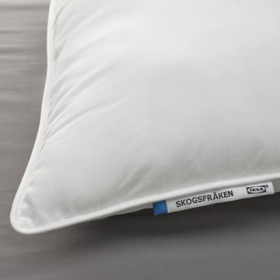 Clean, white pillow with SKOGSFRÄKEN tag, laying on grey bedding. Quality fabric, supportive for back and side sleepers.