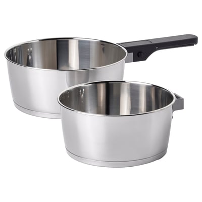 Two stainless steel saucepans with removable black handles, stacked for storage, sleek and modern design.
