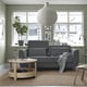 Modern living room with SLATORP grey sofa, wooden coffee table, large window, and hanging lamp. Sofa is centrally placed, larger than side tables.