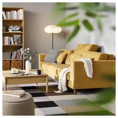 Cosy living room with yellow SLATORP sofa, wooden coffee table, bookshelf, lamp, plant, and chequered rug.