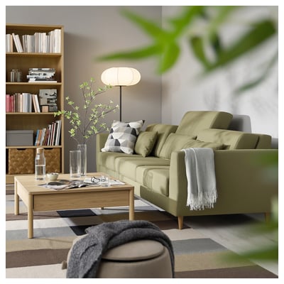 Cosy living room with a green SLATORP sofa, wooden coffee table, and bookshelf. Decorated with pillows, blankets, and plants.