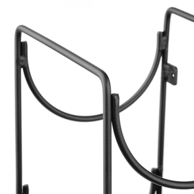 Black metal wine rack detail, curved holder for bottles.