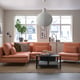 Modern living room with SÖDERHAMN peach-colored sectional sofa, large cosy cushions, coffee table, white pendant lamp, and large windows.