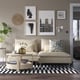 Modern living room with neutral SÖDERHAMN sofa, black & white rug, and light wood coffee table against a grey art-adorned wall.