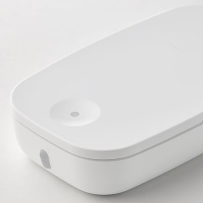 White oval ikea smart button with 3 small circles.