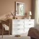 White chest with 6 drawers in bedroom. Between chair and bed, near window.