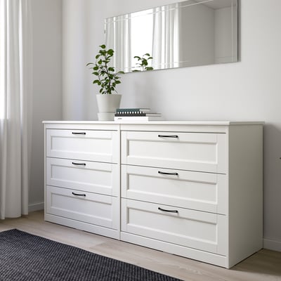 Bright white SONGESAND bedroom set: large chest, mirror, and plant. Classic design with smooth edges, large and spacious.