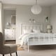 Modern bedroom with STJÄRNÖ white bed, curved headboard, minimalist decor.