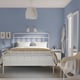 A blue bedroom with STJÄRNÖ bed, white lamp, and oversized furniture.