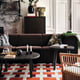 Modern living room with stockholm sofa, colourful pillows, tables, decor, rug, painting, cabinet.