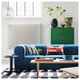 STOCKHOLM 2025 blue sofa with colourful pillows, coffee table, and rug in modern living room.