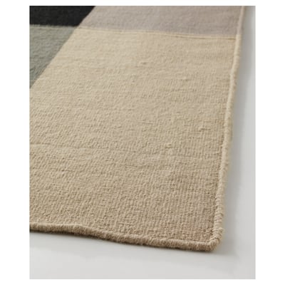 Soft, handwoven beige wool rug with visible texture, ideal for cosy spaces.