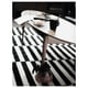 Black and white striped rug under a wooden table with plates and a mug on top.