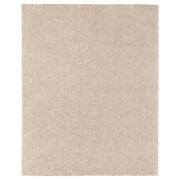 A STOENSE rug in light beige. Its rectangular, soft, and has a subtle sheen. Made of polypropylene, its comfortable and durable.