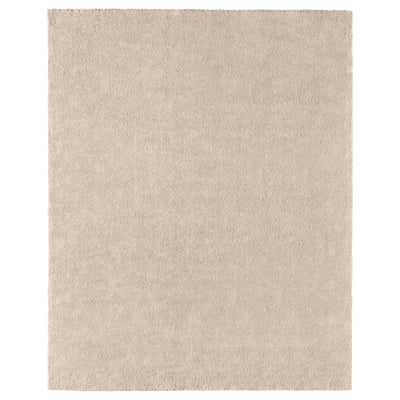 A STOENSE rug in light beige. Its rectangular, soft, and has a subtle sheen. Made of polypropylene, its comfortable and durable.