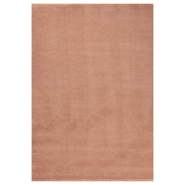 The STOENSE rug in beige. It is rectangular, with a solid colour and simple design, made from polypropylene and synthetic rubber.