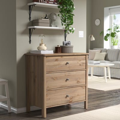 STOREMOLLA chest, light wood, 3 drawers. Decorated with lamp, plants, & books. Large, fits living room.