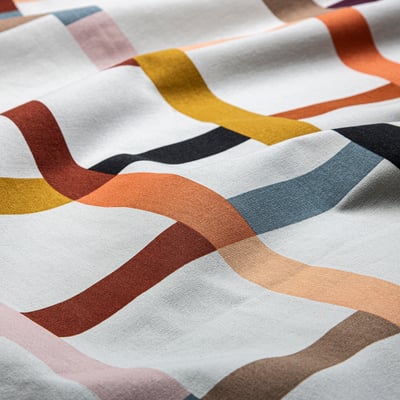 Chequered fabric with wavy lines in various colours. Soft cotton texture, perfect for sewing projects.
