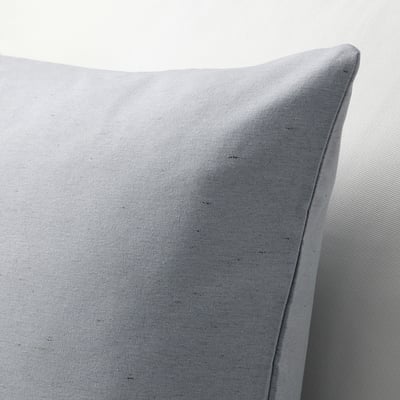 Close-up of soft, textured cushion cover. Natural, slightly varied colour due to recycled cotton. Single piping edge detail.