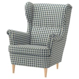 A STRANDMON armchair in blue-and-white chequered fabric, offering a classic wingback design with wooden legs.