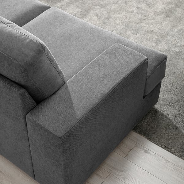Close-up of soft, grey fabric sofa on wooden floor with plush cushions.