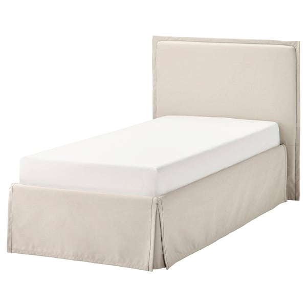 A beige TÄRNKULLEN twin bed with a matching skirt and padded headboard. The bed has a simple, modern design.