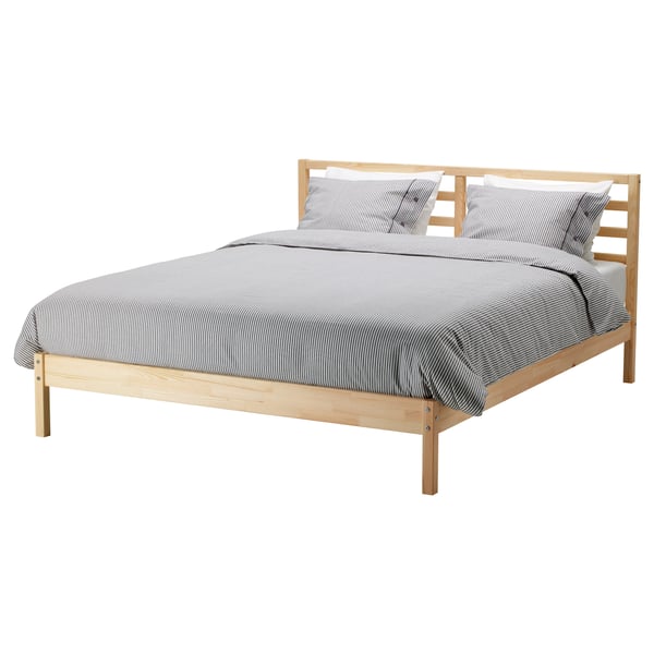 A TARVA bed with a light wooden frame, grey bedding, and two pillows. It a simple, scandinavian design.