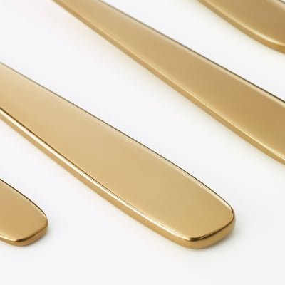 Golden metal cutlery arranged neatly, showcasing reflective surfaces and sleek, modern design.