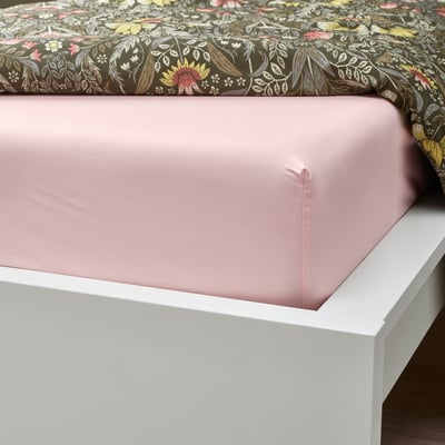 Bed with light pink fitted sheet on white bed frame, showing elastic edging.
