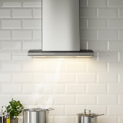 Stainless steel kitchen hood with glass, led lights, front controls.