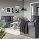 A modern living room with a grey UPPLAND sofa, a coffee table, and decor. The sofa is large, fitting well in the spacious room.