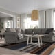 Modern living room with large grey UPPLAND sectionals, white coffee table, striped rug, and wicker pendant light.