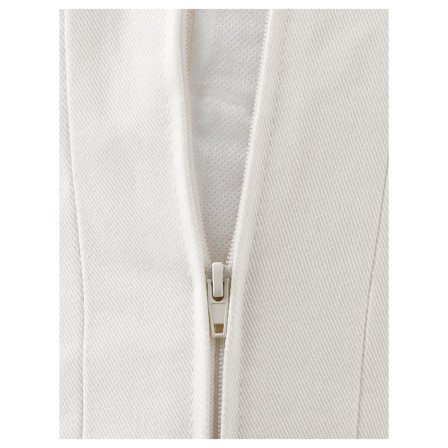 A close-up of a zip on a white fabric sofa, showing how to remove the cover for cleaning.