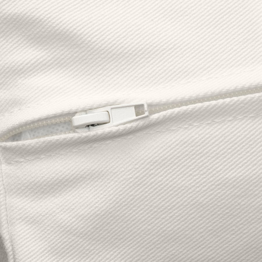 Close-up of a white zip on soft, textured fabric, showcasing quality and detail.