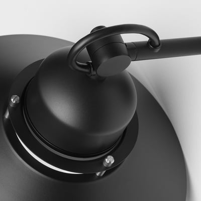 Black outdoor wall lamp with sleek metal design and clear glass shade, mounted securely against a white wall.