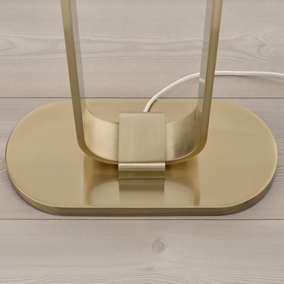 Modern, gold-colored floor lamp with sleek, minimalist design. The base is sturdy and well-polished, reflecting light elegantly.