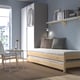 UTÅKER wooden bed with mattress, pillows, and table in modern room