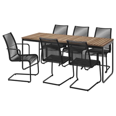 Modern outdoor patio set: brown acacia table, four black wicker chairs, one with armrests, black metal frames.